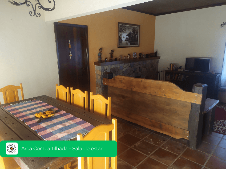 Sala de estar com lareira de pedra na casa principal do Recanto Cravo e Canela, Itatiaia