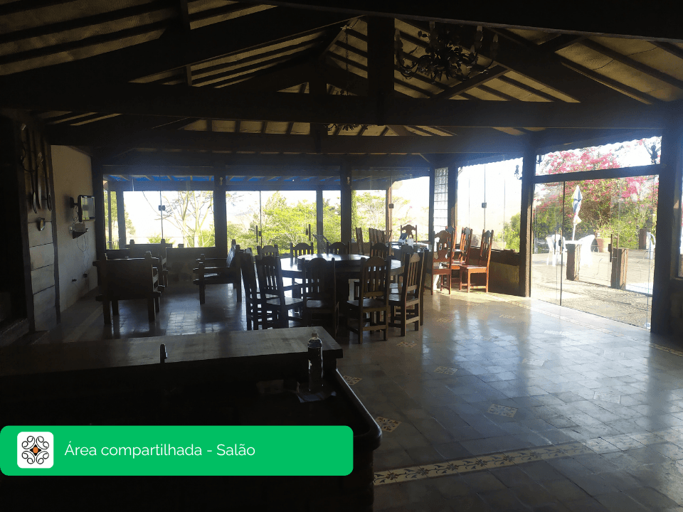 Salão rústico de madeira com vista para o jardim no Recanto Cravo e Canela, Itatiaia